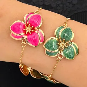 Primer plano de pulseras de flores esmaltadas rosa y verde con cadena dorada mujer
