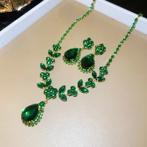 Detailweergave van een smaragdgroene sieradenset met halsketting en druppeloorbellen.