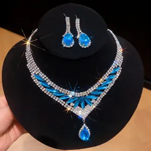 Detailweergave van luxe blauwe zirkoon ketting en oorbellen set op zwarte display standaard