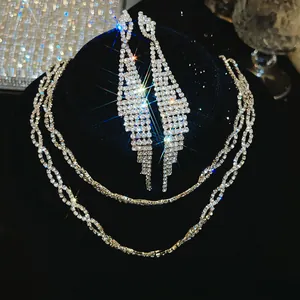 Elegante zilverkleurige zirkonia kwastje sieradenset met fonkelende ketting en oorbellen op fluweel.