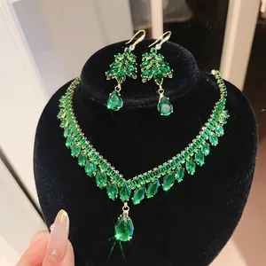 Luxe smaragdgroene zirkoon franje ketting en oorbel set gepresenteerd op zwarte display