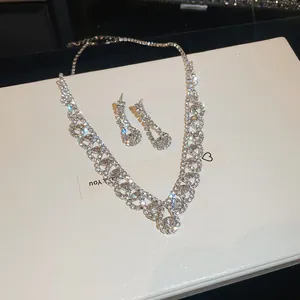 Detail van fonkelende zirkoon kwastje ketting en oorbellen set met zilveren finish