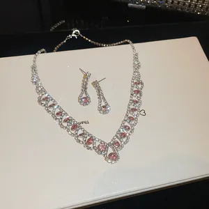Gedetailleerd overzicht van elegante roze zirkonia ketting en oorbellen set met glitters
