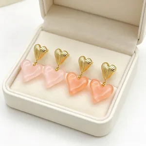 Vue détaillée des boucles d'oreilles cœur Maillard en métal doré et résine rose