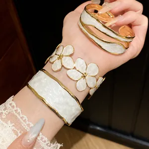 Elegante goudkleurige roestvrijstalen armbanden met wit emaille, golven en bloemen
