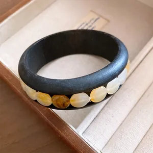 Nahaufnahme eines Retro-Holzarmreifens mit bernsteinfarbenen Acrylperlen-Inlays