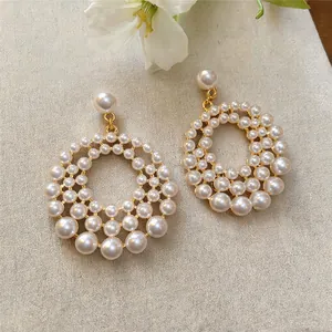 Detailed close-up of French openwork circular earrings with elegant pearl accents
