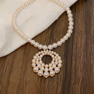 Close-up of elegant French style hollow circular pearl necklace with golden setting.