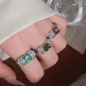 Primer plano de tres anillos abiertos geométricos con forma de abanico y circonitas