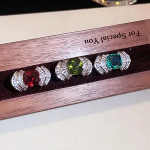 Detalle macro de tres lujosos anillos abiertos en forma de abanico con circonitas de colores.