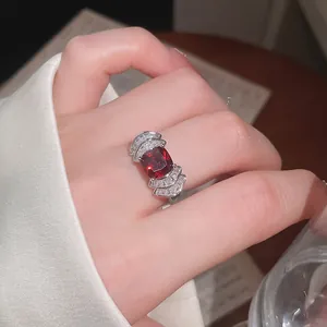 Primer plano detallado de un anillo de circón rojo brillante con diseño geométrico en abanico