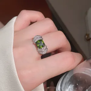 Vista macro de anillo geométrico en forma de abanico con circón verde esmeralda