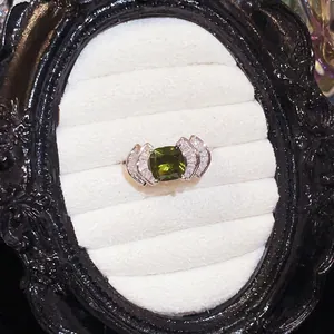 Primer plano de elegante anillo en forma de abanico con un circón verde oliva cuadrado