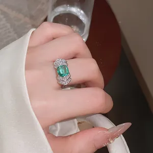 Detalle de un anillo geométrico en forma de abanico con un circón verde esmeralda central