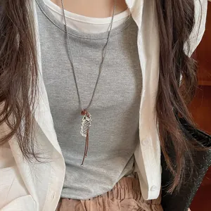 Detail view of a minimalist resin fish pendant necklace with leather cord on a model