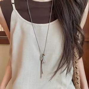 Elegant minimalist silver resin fish necklace detail shown on model in beige linen top