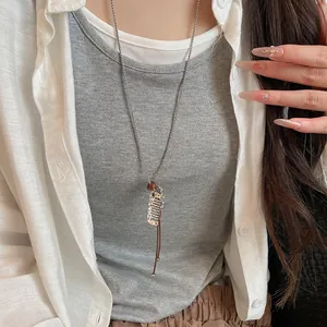 Detailed view of a minimalist Korean fish pendant necklace with leather cord and chain.