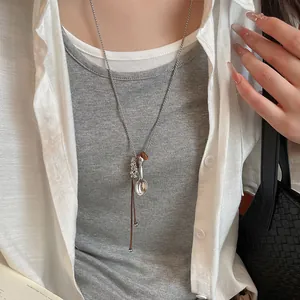 Detail view of a minimalist Korean style long necklace with a silver spoon pendant.