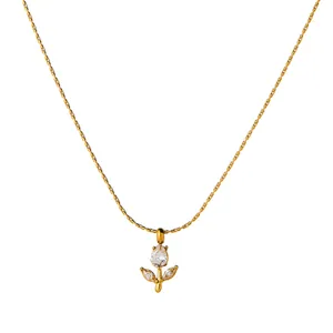 Primer plano de un elegante collar de acero inoxidable dorado con un colgante de flor de circón.