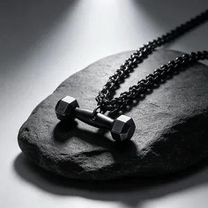 Détail en gros plan d'un collier pendentif haltère noir en acier titane sur une roche sombre