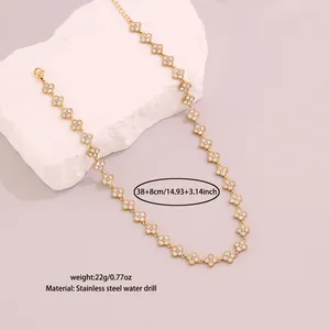 Detail macro view of gold four-leaf flower necklace with rhinestones and steel chain