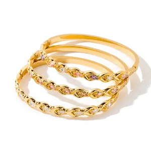 Detailed view of three stacked gold-plated bangles with colorful marquise zircons