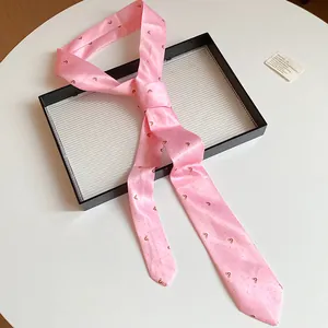 Primer plano de un dulce pañuelo de seda rosa con corazones sobre una bandeja con textura
