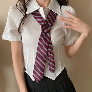 Vista detallada de una corbata de rayas granate combinada con una camisa blanca de manga corta