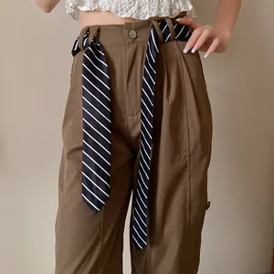 Detalle de una corbata a rayas blancas y negras usada como cinturón para pantalones