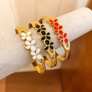Elegant vintage style gold bangles with colorful enamel flower patterns in white black and red