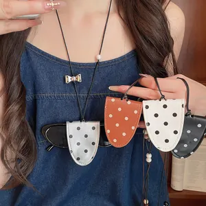 Close-up of stylish polka dot leather glasses sleeves used as a neck hanging accessory