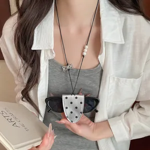 Close-up of a stylish silver polka dot leather sunglasses holder necklace on a model