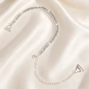 High-quality close-up detail of silver double row rhinestone bra straps on silk background