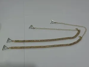 Detailed view of sparkling rhinestone bra straps featuring adjustable gold chain and hooks