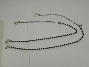 Detail view of silver bra straps with black rhinestones and triangle hooks