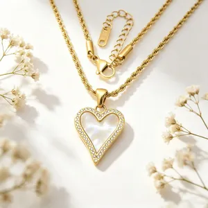 Détail du pendentif cœur en nacre blanche et cristaux brillants sur une chaîne torsadée
