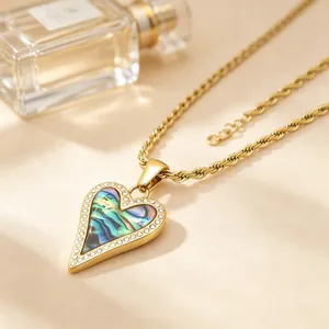 Détail du collier cœur doré avec nacre irisée et bordure en cristal sur chaîne corde