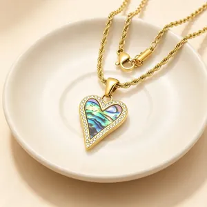 Gros plan sur le collier pendentif cœur doré avec nacre colorée et cristaux