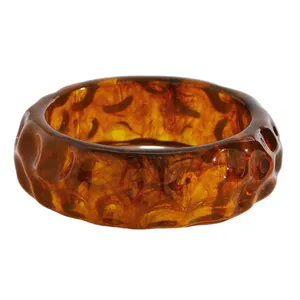 Detailed view of wide tortoiseshell resin bangle with irregular hammered texture