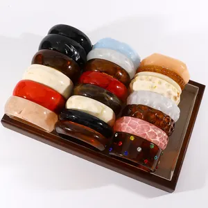 Collection of retro marbled resin wide bangles in diverse colors displayed in a wooden tray