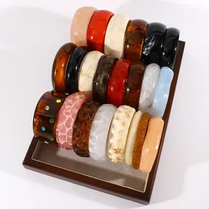 Detailed view of vintage marbled resin wide bangles in various colors and patterns