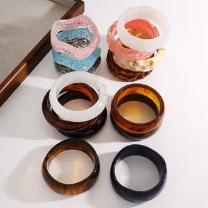 Collection of vintage resin and acrylic wide bangles with colorful marble and glitter patterns