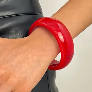 Close-up of a vibrant red vintage resin wide bangle bracelet with subtle marbling