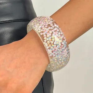Detail view of chunky transparent resin bangle with colorful iridescent glitter