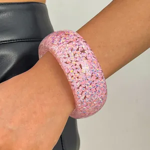 Close-up detail of a vintage pink resin wide bangle featuring iridescent glitter shards