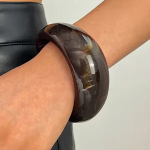 Close-up detail of a vintage marbled resin wide bangle with tortoise pattern on wrist