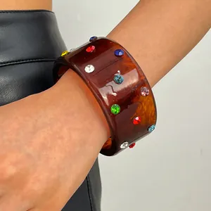 Close-up of vintage resin wide bangle with colorful rhinestones and tortoiseshell pattern