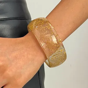 Close-up of retro wide resin bangle featuring sparkling gold foil inclusions