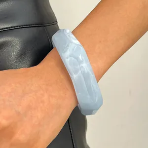 Detailed close-up showing a vintage light blue marbled resin wide bangle worn on a wrist