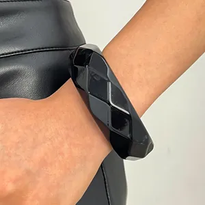 Close-up macro view of a vintage style black faceted resin wide bangle worn on a wrist